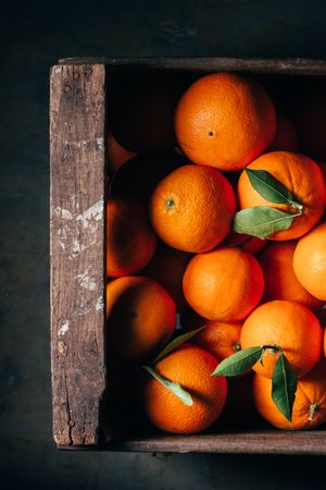 Fresh oranges in an old wooden box