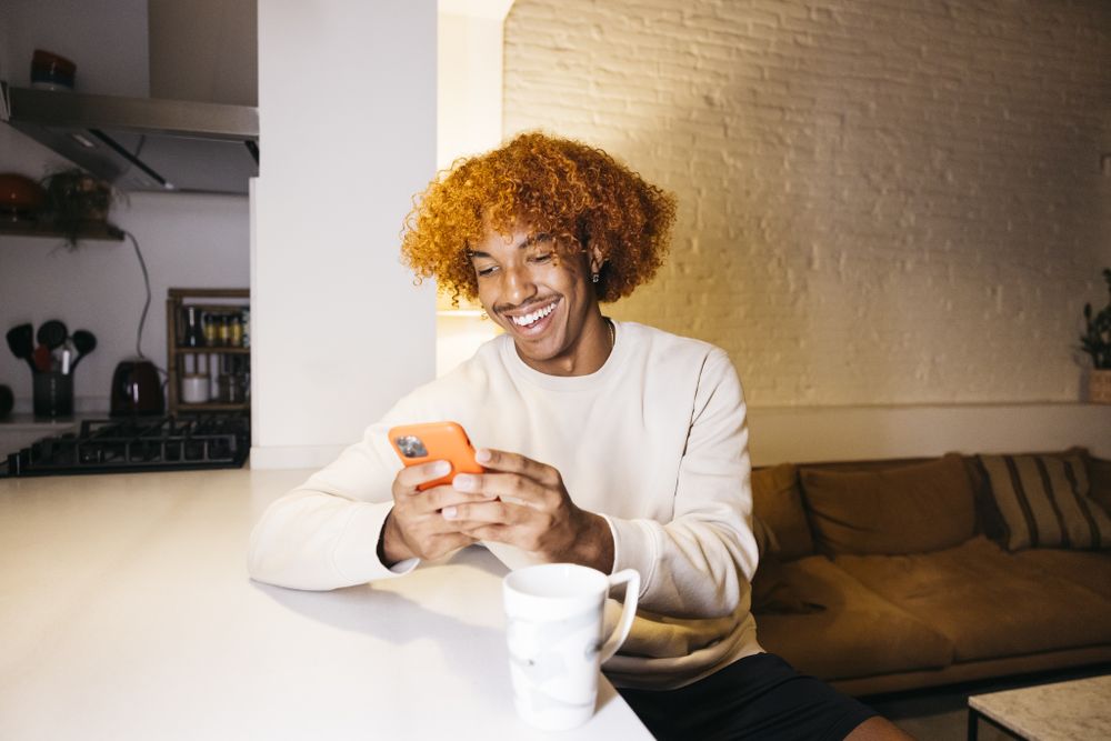 Young man using phone at home.