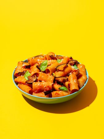 Pasta with eggplant dish isolated on a yellow background