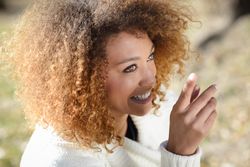 Smiling woman pointing up at something on sunny day