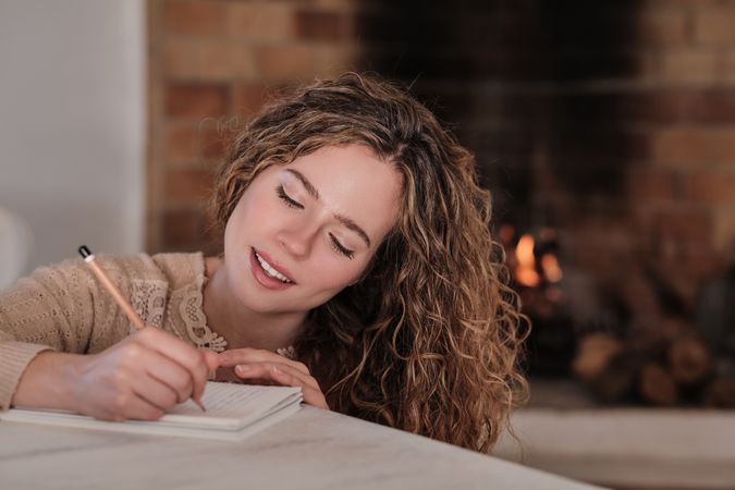 Smiling young female writing in diary