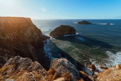 High cliff near water in sunny day