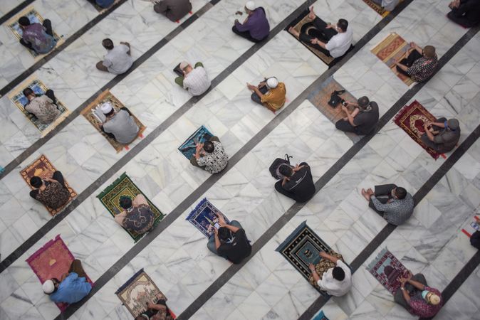 Top view of Muslim men praying and social distancing in mosque