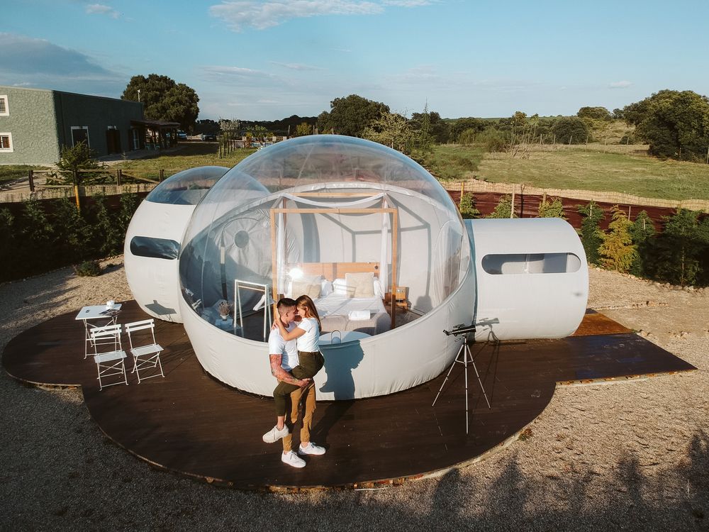 Young couple kissing by unusual bubble hotel