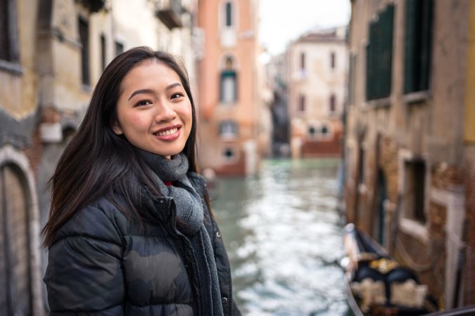 Satisfied Asian resting woman exploring old city with waterways