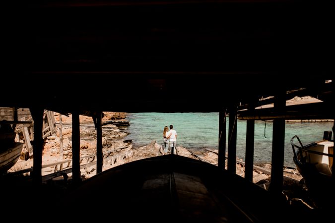 Amorous couple hugging on coastal pier