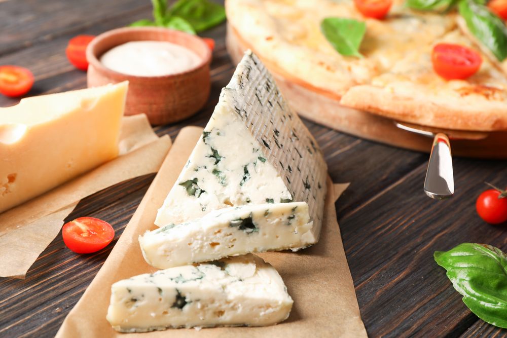 Cheese pizza and ingredients on wooden background, closeup