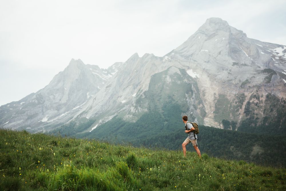 Unrecognizable man with backpack hiking in Pyrenees mountains