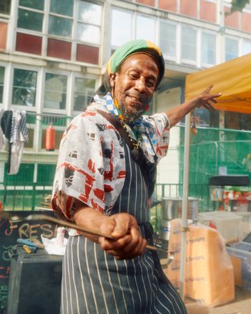 London, England, United Kingdom - August 27, 2022: Man in apron cooking street food in Notting Hill