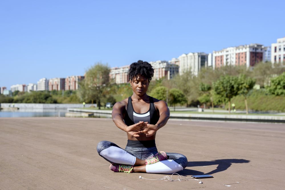 Black sportive woman sitting and stretching