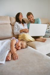 Mother and father watching movie on laptop