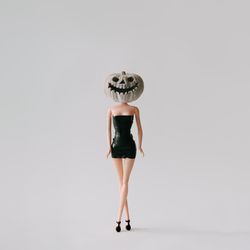 Doll in dress with pumpkin skull head