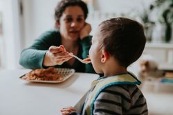 Woman feeding toddler