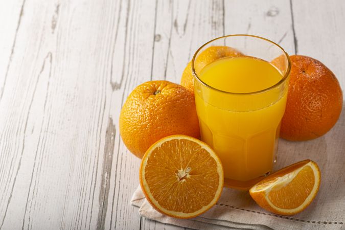 Glass with orange juice on the table.