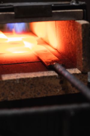 Metal detail burning in furnace in workshop