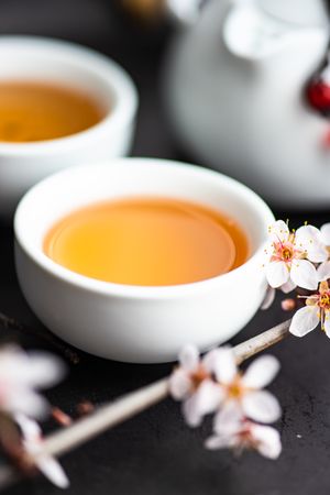 Two cups of tea with floral garnish