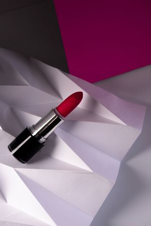 Pink lipstick on raised chevron. Product and make up contemporary concept