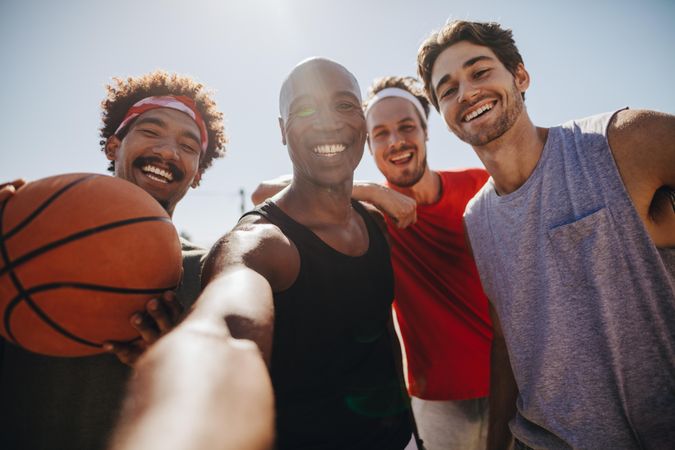 Group of men posing for selfie holding a basketball