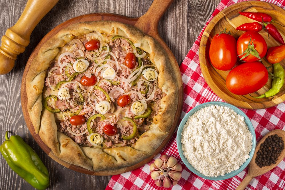Wooden table with ingredients for pizza.