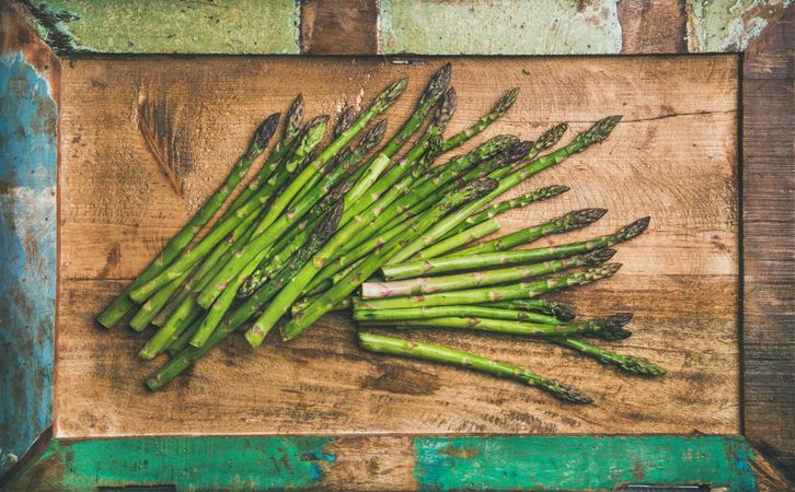 Scattered pieces of  asparagus, on wooden board, horizontal composition