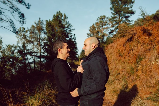 Men hugging and kissing in park