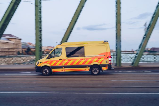 Bright yellow van riding on road in speed