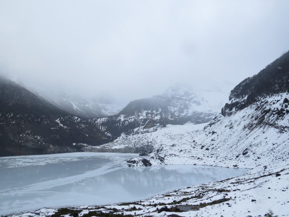 Frozen lake beside snow covered mountain