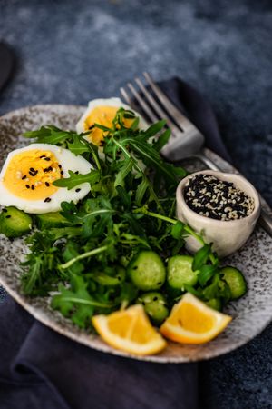 Healthy salad with hard boiled egg, cucumber with lemon slices