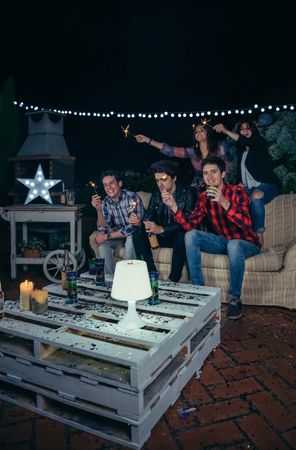 Fun friends holding sparklers at an outdoor party