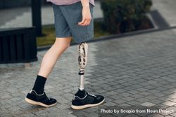 Cropped image of young man with prosthetic leg walking bEXxM4