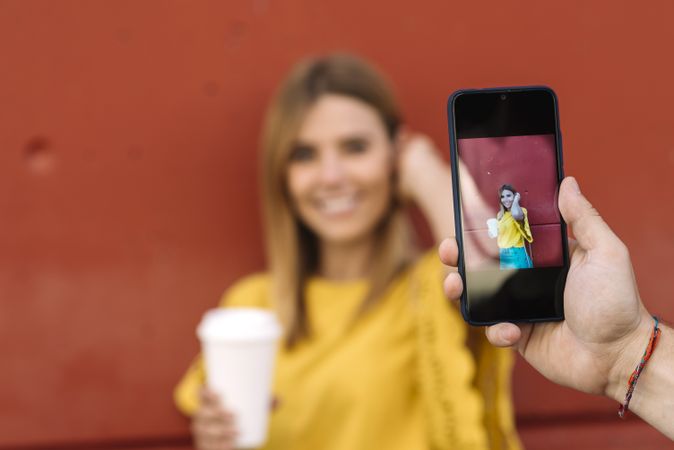 Young woman posing with coffee for man