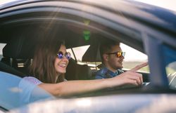 Young man driving a car with his girlfriend
