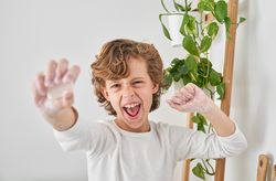 Excited boy reaching out hand with soap