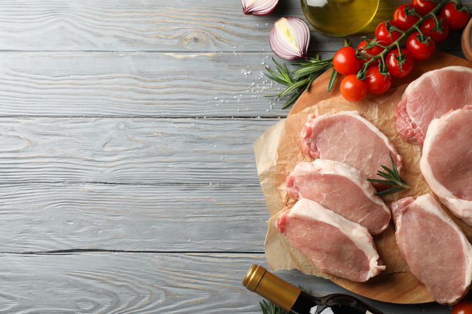 Composition with raw meat for steak and ingredients on wooden background