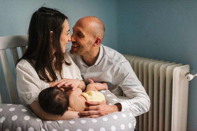Happy parents feeding baby