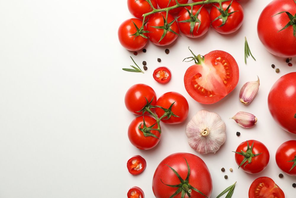 Composition with tomatoes and ingredients on light background, top view