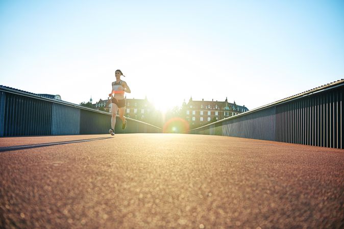 Bright European bridge with female jogger