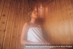 Woman sitting in a wooden sauna spa taking steam bath 0Ld3Pr