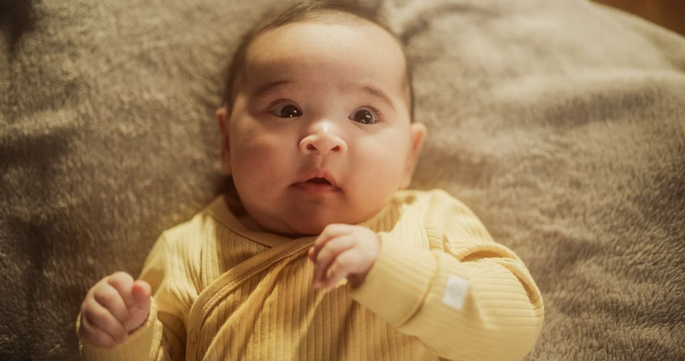 Portrait of a Cute Asian Baby Resting in a Crib, Surrounded by a Soft Blanket.