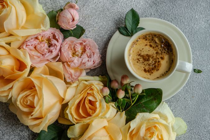 Beautiful floral card concept with fresh yellow and pink roses with cup of coffee