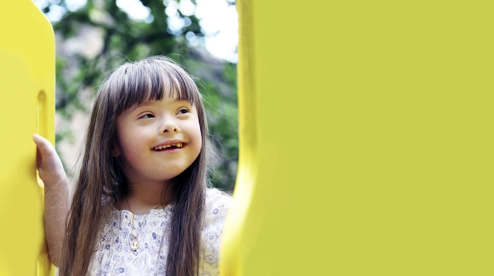 Adorable little girl missing one front tooth smiling and having fun at the playground
