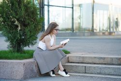 Curious woman in glasses reading outside