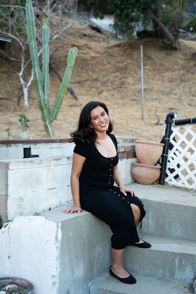 Woman with beautiful smile sitting on steps in her yard looking at camera