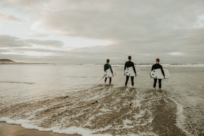 People with surfboard walking near sea