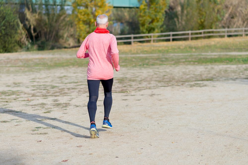 Back of mature man jogging outside