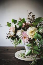 Composition of flowers and plants in vintage vase on board