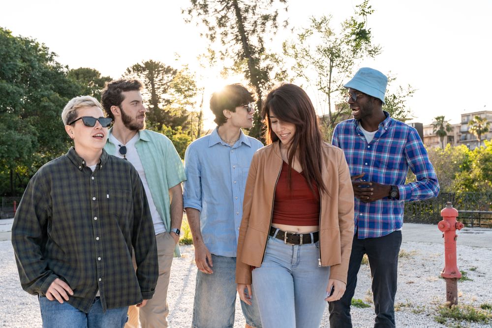 Candid shot of a diverse group of friends walking and talking together outdoors.