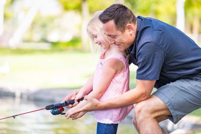 Father and Daughter Having Fun Fishing At The Lake