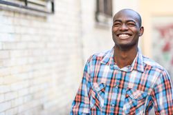 Happy male in plaid shirt walking down alley way