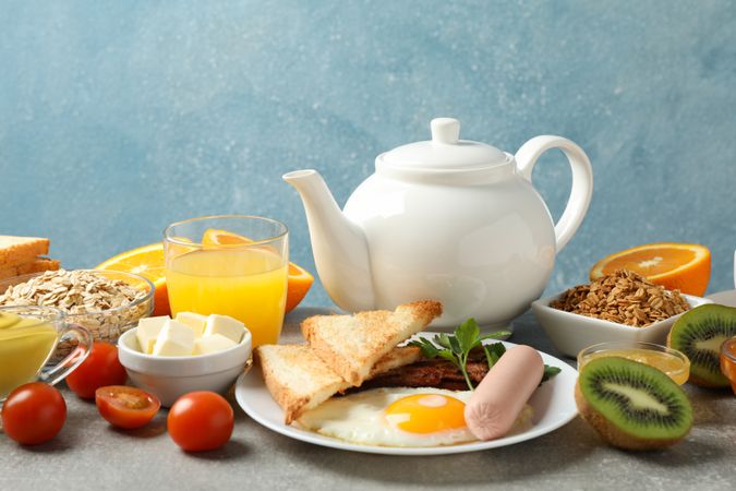 Pan of breakfast fry up against a blue background, copy space